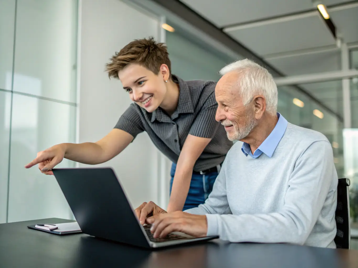 A technician is assisting a business owner with the setup of new software on a computer, ensuring a smooth integration process.